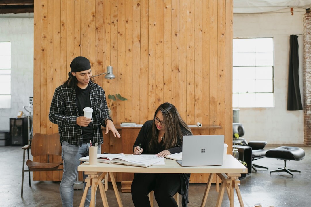Professionals collaborating around a table with laptops and documents